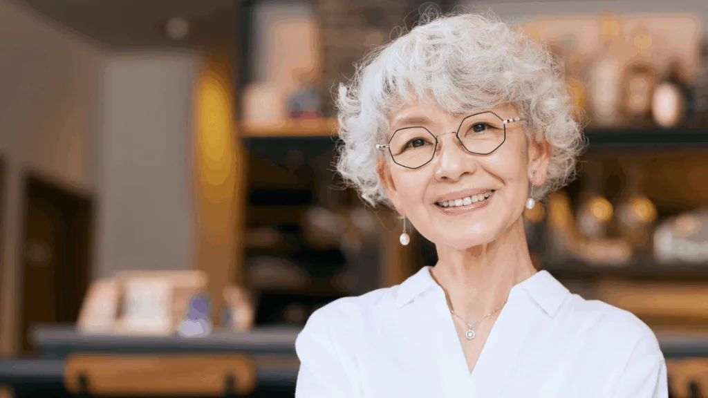 A fashionable older woman sits in a community coffee shop